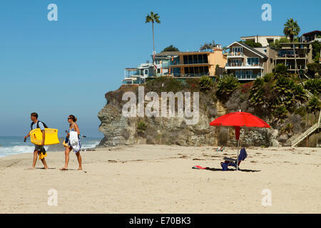 Bright red umbrella and clifftop homes at Thousand steps Beach in Laguna Beach California Stock Photo