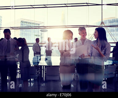 Silhouettes Of Multi-Ethnic Group Of Business People Working Together In A Board Room Stock Photo