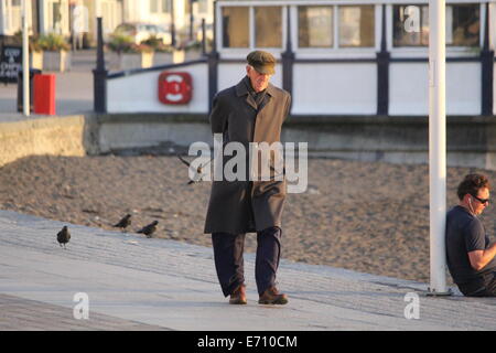 AN ELDERLY MAN TAKES AN EVENING WALK PAST THE BANDSTAND IN ABERYSTWYTH Stock Photo