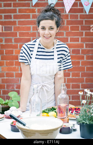 Portrait of young woman preparing food at garden party Stock Photo