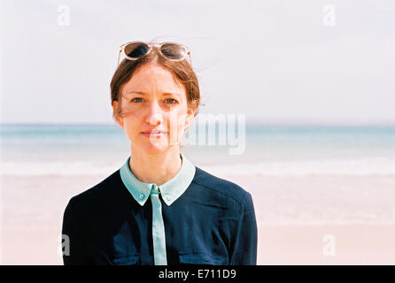 A woman standing on a beach with her back to the ocean. Stock Photo