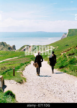 Two women walking on a coastal footpath along cliffs. Stock Photo