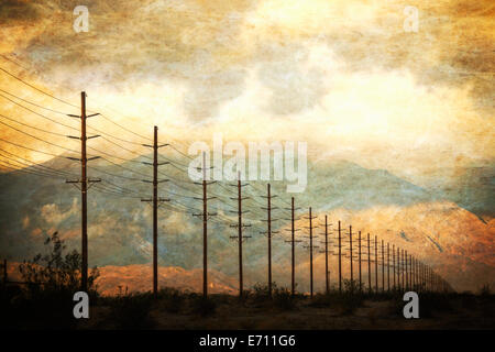 Power lines in rows across the landscape, against a sunset sky. Stock Photo