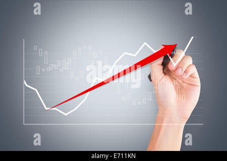 Business and finance concept, young male hand holding pen and drawing graph chart with red arrow on digital screen. Stock Photo