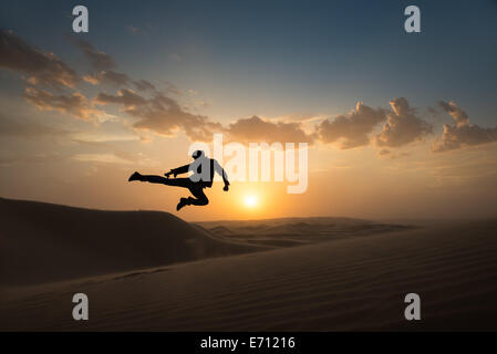Man jumping mid air, Glamis sand dunes, California, USA Stock Photo