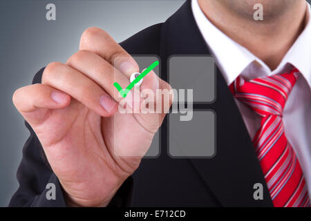 Businessman holding pen and checking check mark of list on digital screen. Stock Photo
