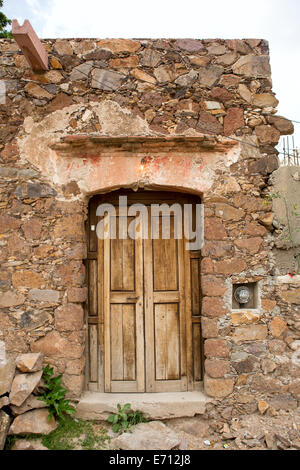 old wooden door on a run down stone house Stock Photo