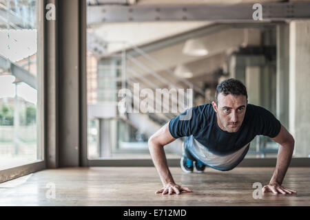 Mid adult man doing pushups Stock Photo