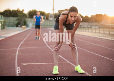 Woman leaning forward on racing track Stock Photo