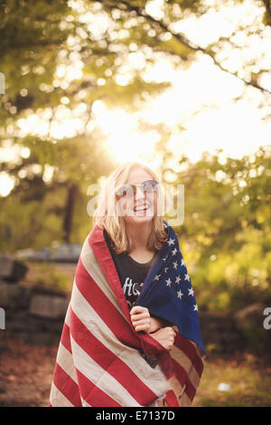 Young woman wrapped in US flag, portrait Stock Photo