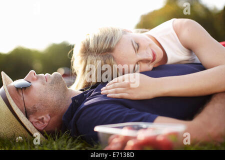 Couple lying asleep in park