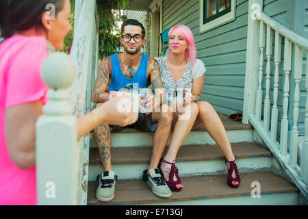 Young adult friends chatting on porch steps Stock Photo
