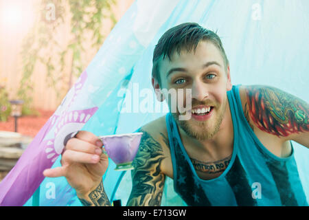 Portrait of young man with teacup in tent