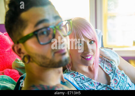 Portrait of funky couple reclining on bed Stock Photo