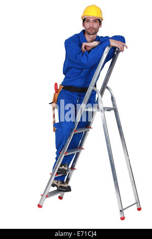 Handyman stood on ladder Stock Photo