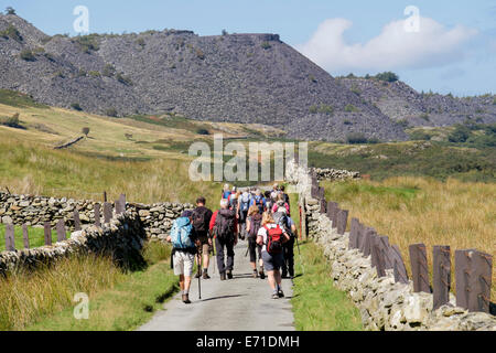 Ramblers group walking club hiking on a country lane in Nant Ffrancon valley in Snowdonia National Park. Bethesda, Gwynedd, North Wales, UK Britain Stock Photo