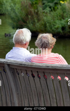 Elderly couple take a break beside lake at RHS Wisley Surrey Stock Photo