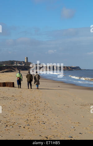 Happisburgh, Norfolk. England. UK. Winter beach walking. Church and village on horizon. Stock Photo