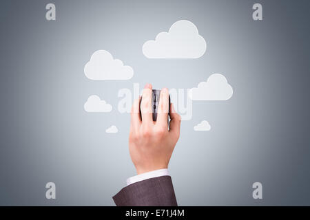 Technology concept, businessman hand holding mouse with cloud symbols on dark background. Stock Photo