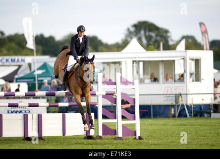 A show jumping rider and horse clear an obstacle during the Longines ...