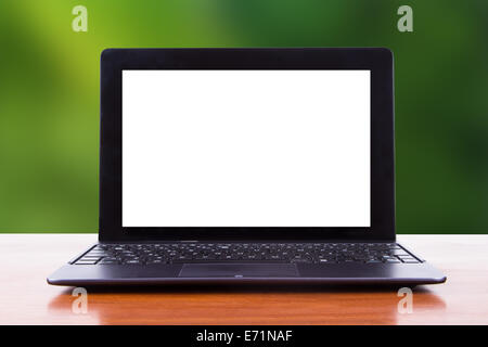 Tablet laptop with white blank screen on wooden table, front view, green natural background. Stock Photo