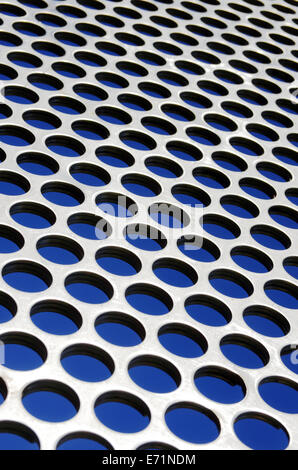 Aluminum perforated grid against a blue sky under sun light Stock Photo