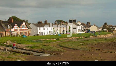 Beachfront houses, grassy parkland, and deserted beach at low tide at coastal village of Ravenglass, Cumbria, England Stock Photo