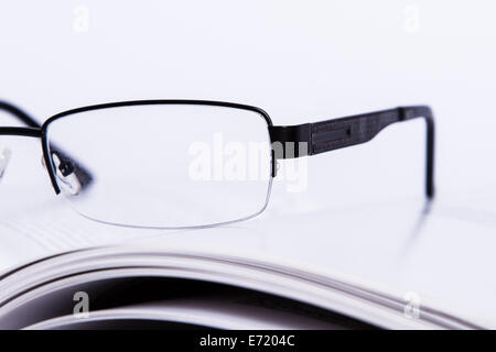 Eyeglasses on opened book, isolated on white background. Stock Photo