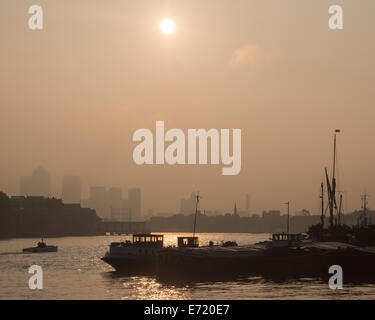 London, UK, 4th September 2014. Ships and boats moored in the Thames are silhouetted against golden skies as London wakes to a beautiful misty morning. The Meteorological Office has forecast a fine late summer for England. Credit:  Patricia Phillips/Alamy Live News Stock Photo