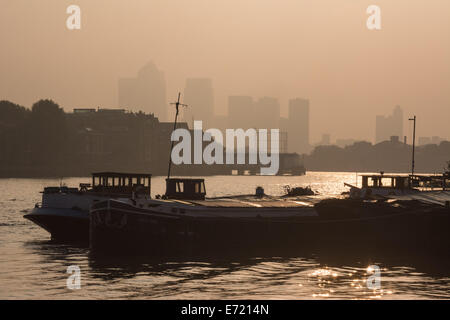 London, UK, 4th September 2014. Ships and boats moored in the Thames are silhouetted against golden skies as London wakes to a beautiful misty morning.  Credit:  Patricia Phillips/Alamy Live News Stock Photo