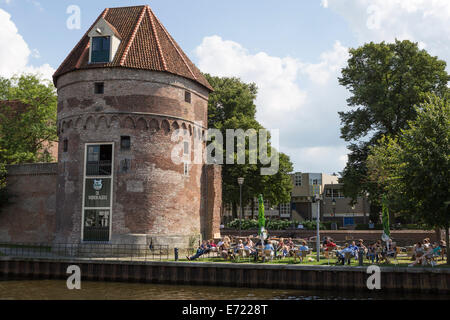 People relaxing at a terrace near a medieval tower belonging to the city walls of Zwolle in the Netherlands (province Overijssel Stock Photo