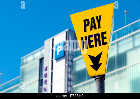 Pay here sign in front of modern multi storey car park Stock Photo