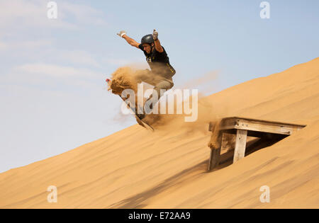Sand boarding in the dunes of the Namib Desert, near Swakopmund, Namibia Stock Photo