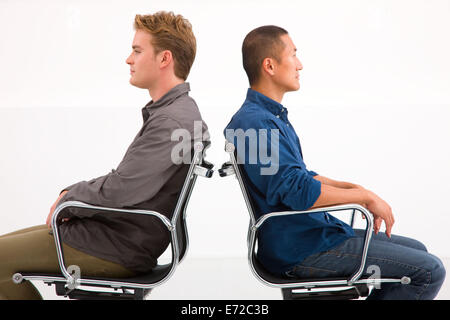 Two businessman sitting in chairs to back Stock Photo