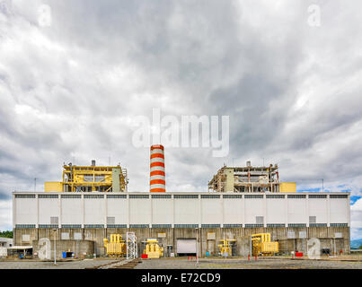 Old coal power plant in Asia shot against ominous dark clouds Stock Photo