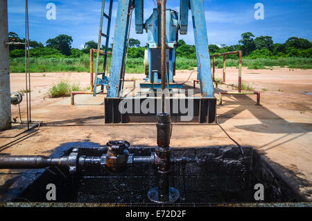 Onshore oil well (pumpjack) in Angola (Soyo province), close-up on the pump and petrol spill Stock Photo