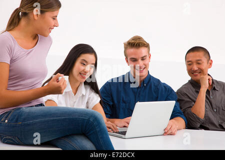 Group of happy friends using laptop Stock Photo