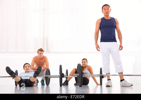 Multiethnic group of people resting after workout in gym Stock Photo