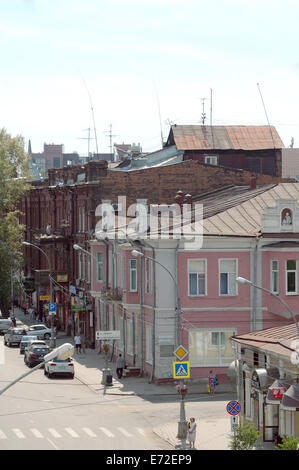 Private wooden log house on the roof of a three-storey building in the historic city center. Irkutsk, Siberia, Russian Federatio Stock Photo