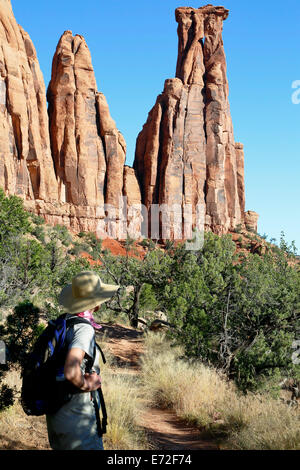 Female hiker below Kissing Couple sandstone monument, Canyon Monuments Trail, Colorado National Monument, Grand Junction USA Stock Photo
