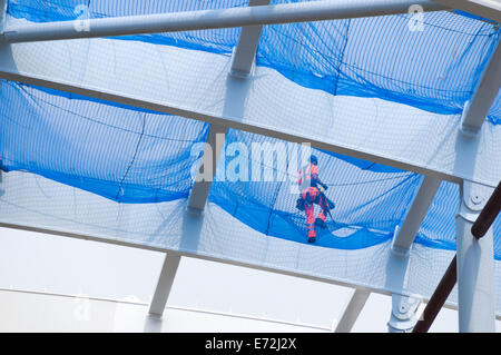 Worker on safety netting on the new roof which is being constructed at Victoria Station, Manchester, England, UK Stock Photo