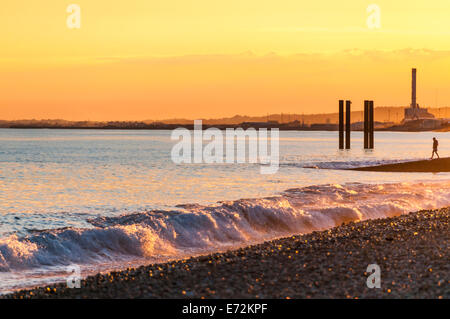 Summer evening light on the waves breaking onto Brightons pebbly beach Stock Photo