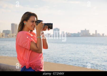 Portrait of young beautiful girl in la habana, cuba, taking pictures and photo of sea Stock Photo