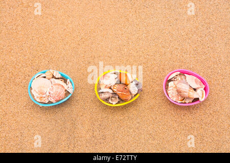 Decorative Easter egg baskets on the beach filled with seashells for use as a background. Room for copy left along the top half Stock Photo