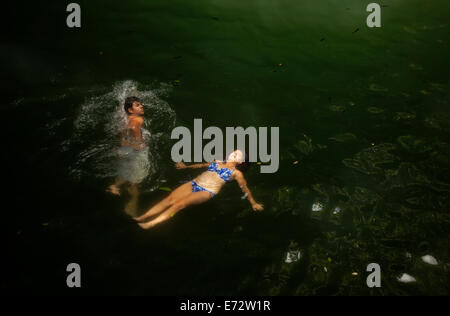 A woman swims in Xcanche Cenote near  the Mayan city of Ek Balam, Yucatan Peninsula, Mexico, August 10, 2014. Stock Photo