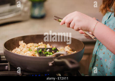 Teenage girl (13-15) cooking in kitchen Stock Photo
