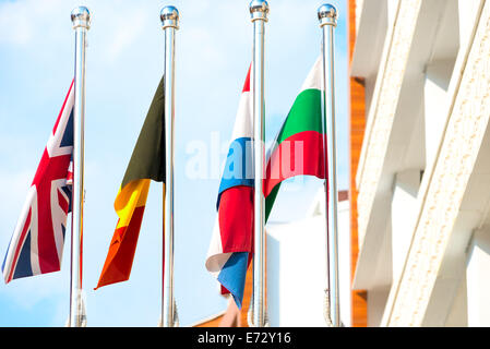 four flags on flagpoles countries Stock Photo