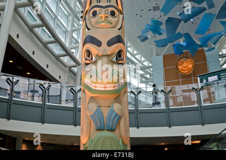 Beautiful Canadian Indigenous totem pole artwork greets visitors in the Vancouver International Airport, YVR. In the Graham Clarke Atrium. Stock Photo