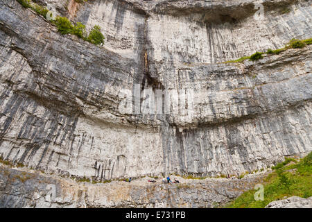 A climber is dwarfed by the cliff face of Malham Cove Stock Photo