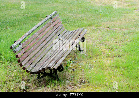 old moss-covered bench on a green lawn Stock Photo